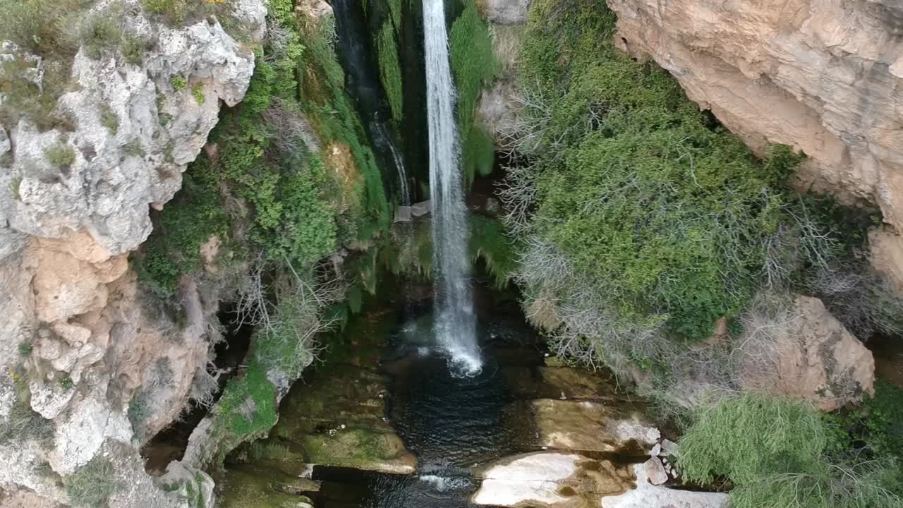 vistas aéreas de una cascada con una cueva y un edificio antiguo en cataluña, españa