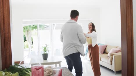 Feliz-Pareja-Caucásica-Bailando-Juntos-En-La-Sala-De-Estar,-Cámara-Lenta