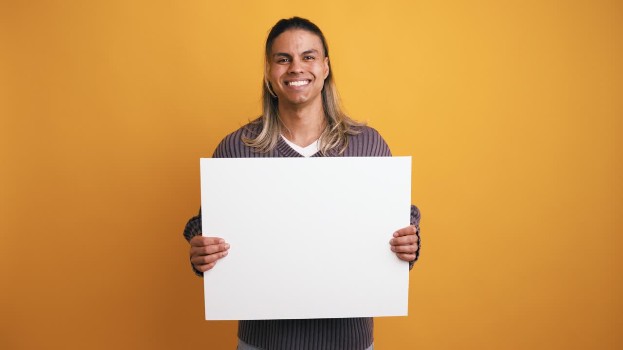 Smiling Young Man Holding Blank White Sign on Yellow Background