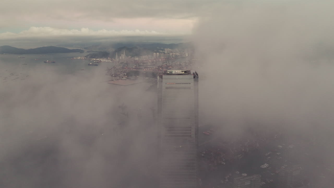 ICC skyscraper appearing between low clouds in Hong Kong