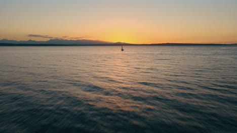 Aerial-approaching-shot-of-sailing-boat-on-sea-against-golden-sunset-in-the-evening