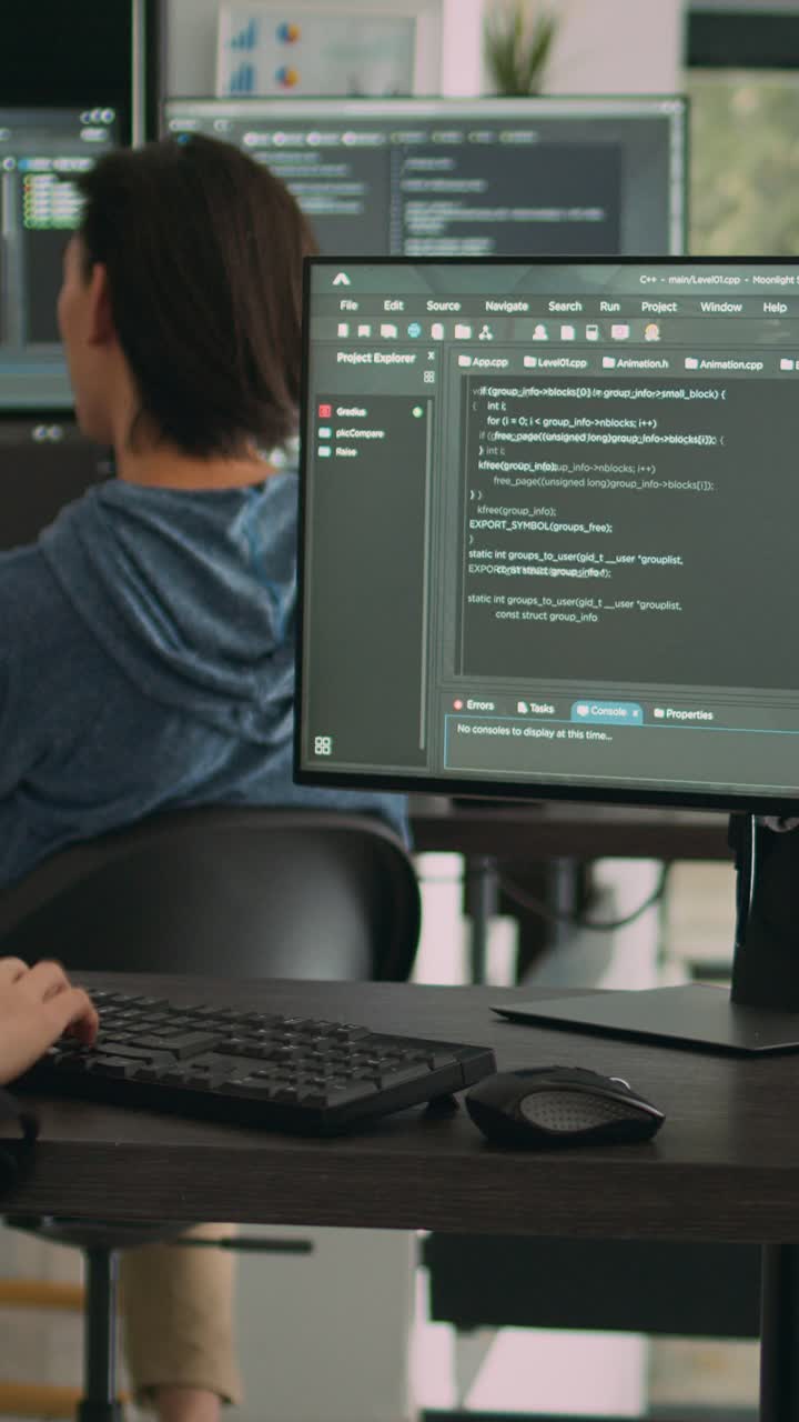 Vertical video: Asian software engineer working with user interface on computer screen