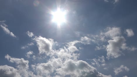 beautiful view at sunbeams with some lens flares and clouds in a blue sky