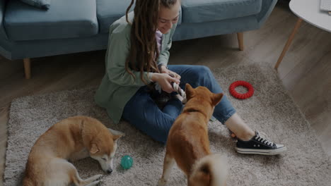 woman playing with dogs on a rug