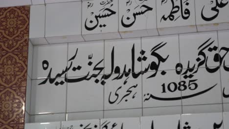 Close-up panning shot of Arabic calligraphy on tiles