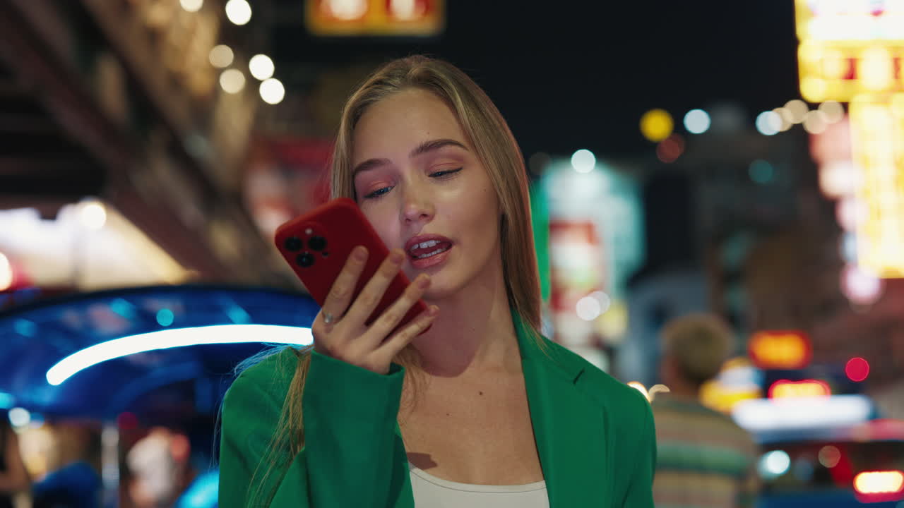 Giovane donna che usa lo smartphone di notte in città