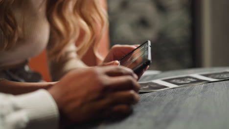 guy with girlfriend holds phone with baby ultrasonic record