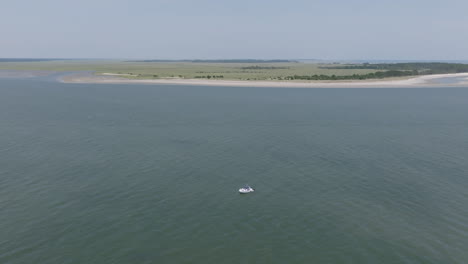 Aerial video shows a small boat anchored offshore with Hilton Head’s wide sandbars and grassy flats in the background