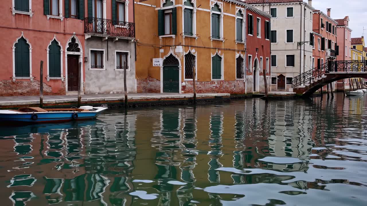 Tranquil canal scene with colorful buildings reflecting in water, showcasing the serene beauty of urban waterways and architectural harmony in motion