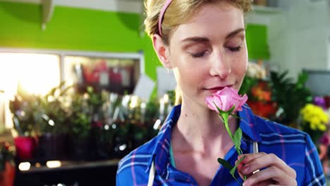 Beautiful-female-florist-smelling-bunch-of-pink-rose