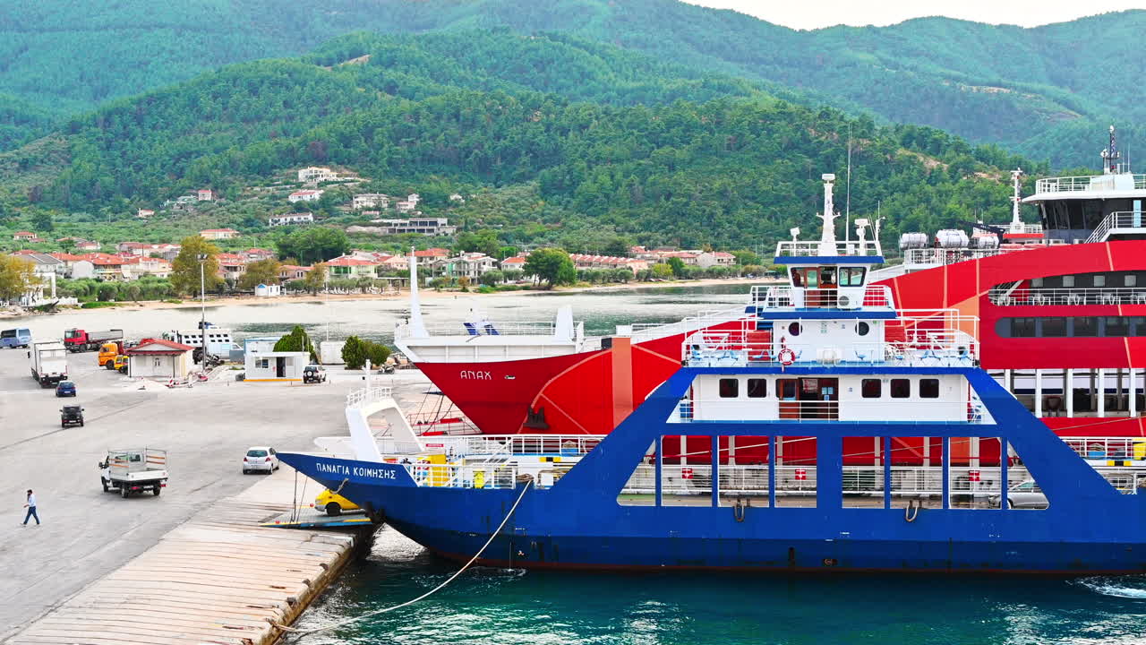 THASOS, GRÆKENLAND - 23. SEPTEMBER 2020: Fortøjede færger med blåt og rødt ydre, åbnede landgangsbroer i havnen, biler kører ud af skibet