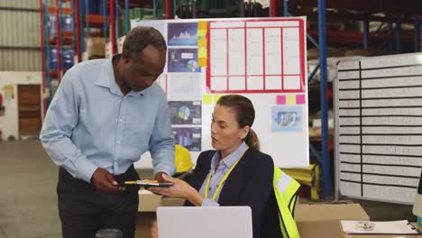 man and woman working at a desk in a warehouse 4k