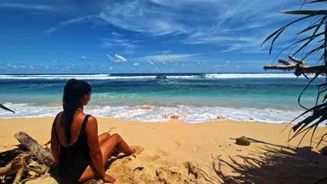 an attractive woman enjoys sandy beach and endless ocean on bali island