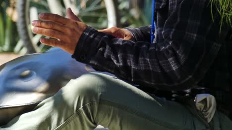 Closeup-of-a-man-playing-some-kind-of-strange-drum-like-instrument-like-bongos-on-a-beautiful-sunny-day