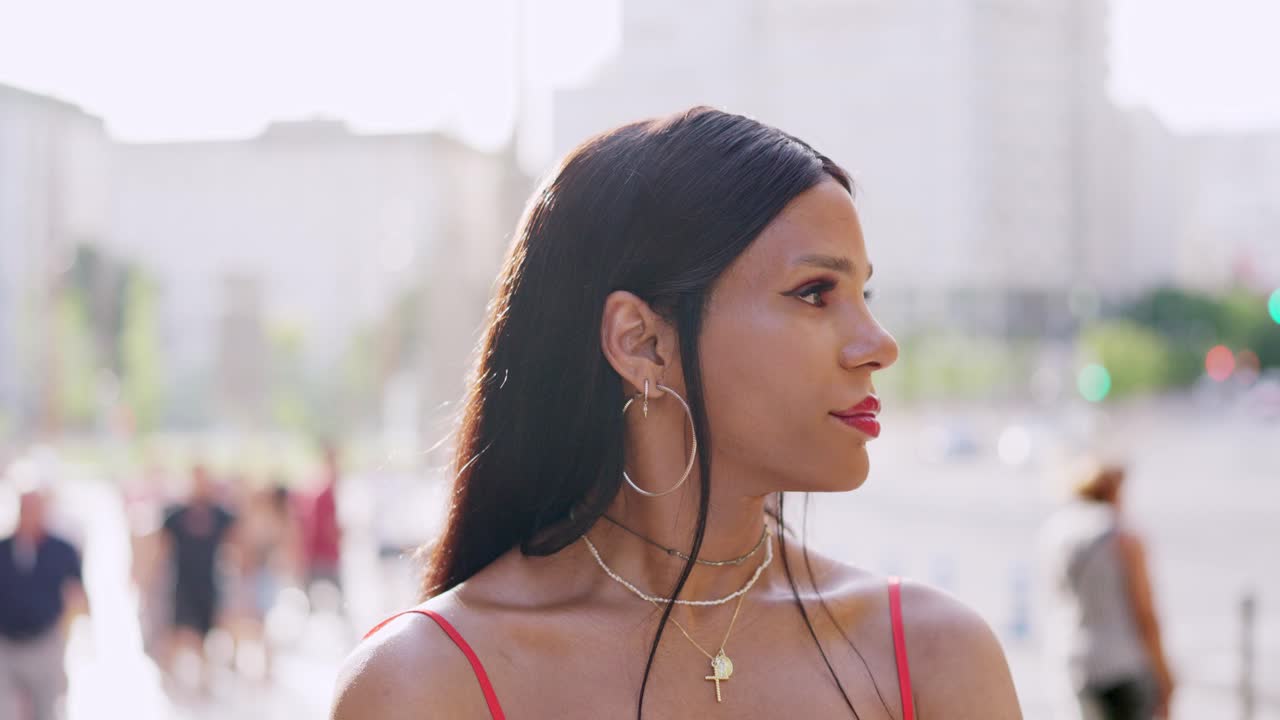 Portrait of a person with makeup and jewelry in an urban outdoor setting.