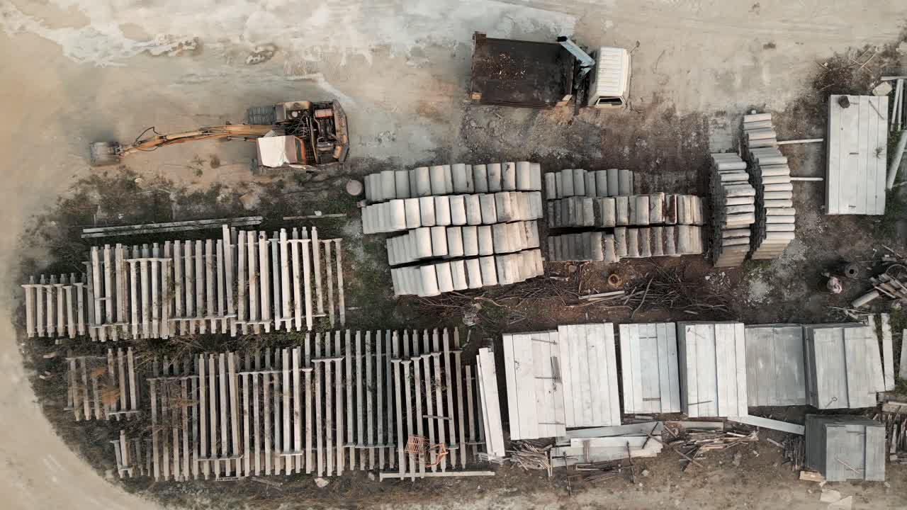 Aerial view of a construction material storage yard with heavy equipment