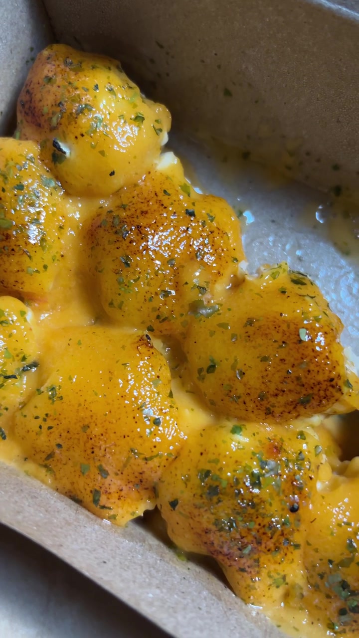 Close-up of Golden Cheesy Bread Bites with Herbs and Sauce