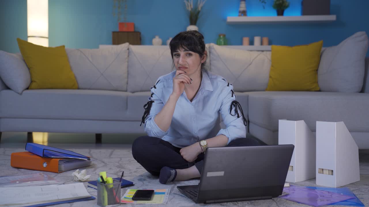 una trabajadora de oficina en casa mirando a la cámara con asco y odio.