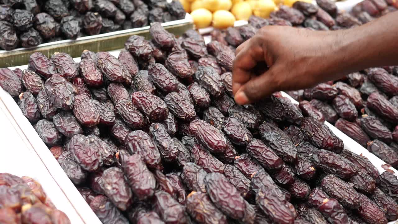Hand picking dates from a market stall