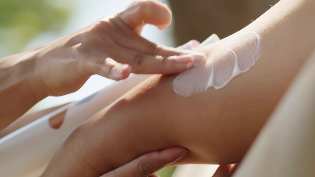 Sunlit Hands Applying Lotion To Leg, Spa Therapist Gently Massaging Moisturizer Into Skin Outdoors, Warm