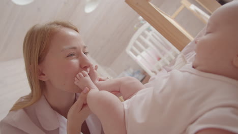 mother kissing her baby's foot