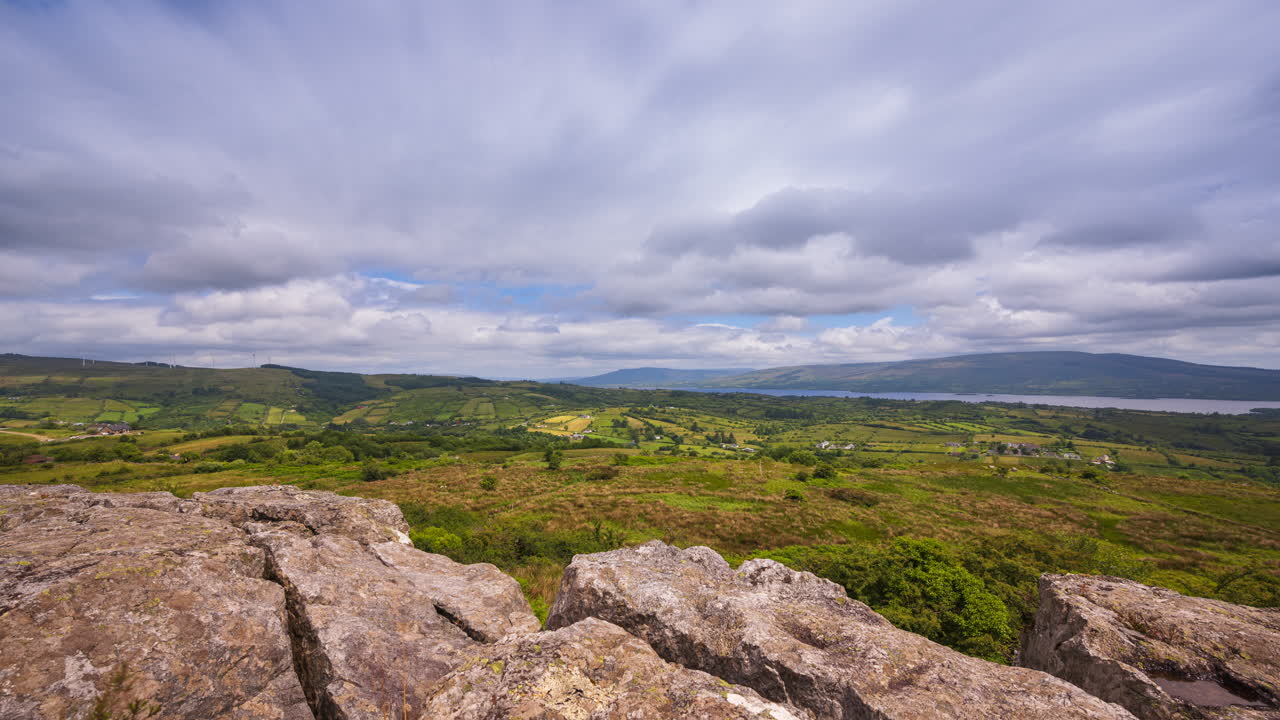 Time lapse of rural landscape with rocky foreground and hills and lake in the distance on a sunny cloudy day in Arigna mountains in county Leitrim in Ireland