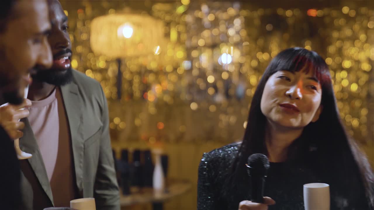 tiro de seguimiento alejándose de un grupo de amigos cantando en un bar de karaoke