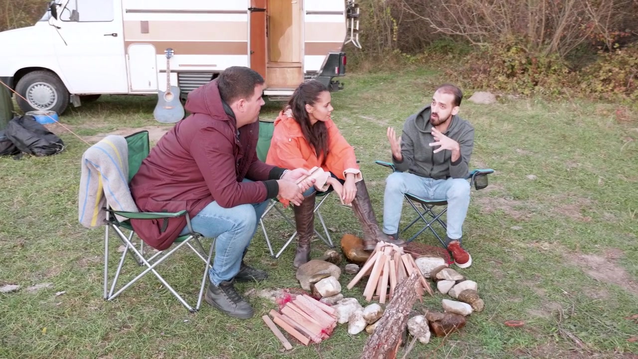 Venner samles omkring et bål på en bjergcampingplads