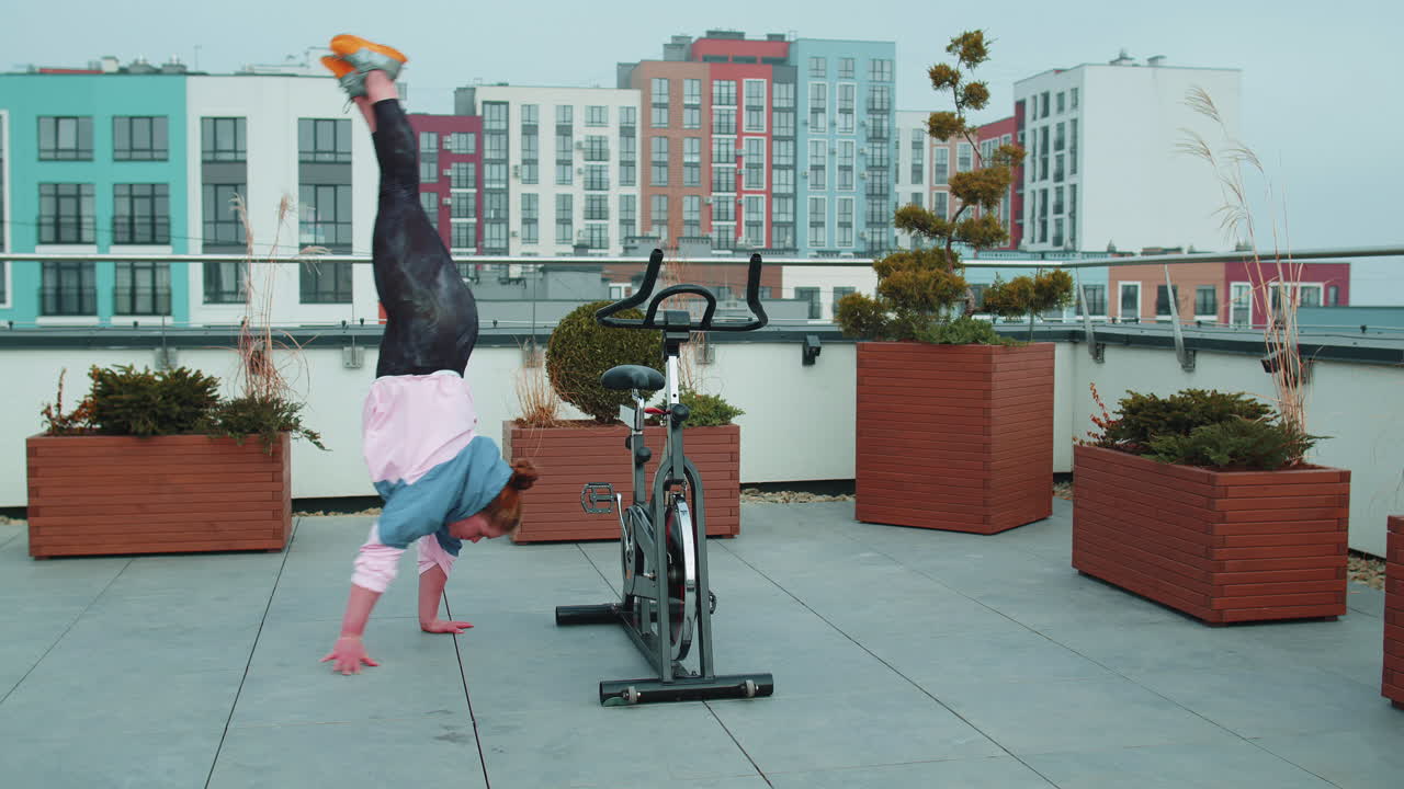 운동 여자 는 자전거 를 타고 아크로바틱 트릭 을 하고, 정지 된 자전거 기계 에서 운동 을 하고, 야외 에 있다