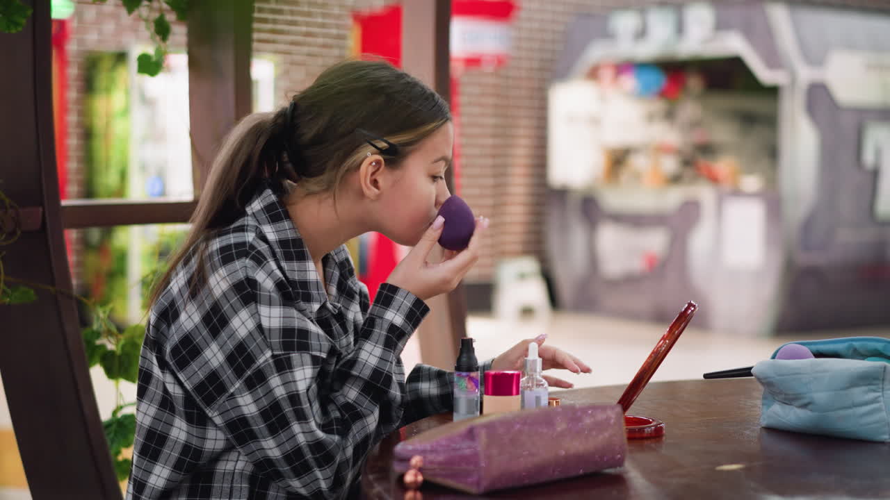 mujer con camisa a cuadros comprobando y ajustando cuidadosamente su maquillaje delante del espejo. productos de belleza, cosméticos, fondo muestra un entorno de arcade borroso con luces brillantes