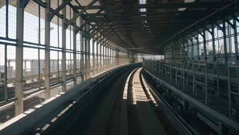 Sonnenlicht,-Das-Durch-Metallrahmenwände-Geht,-Während-Die-Yurikamome-Einschienenbahn-In-Der-Tunnellinie-Unter-Der-Regenbogenbrücke-In-Tokio,-Japan,-Fährt