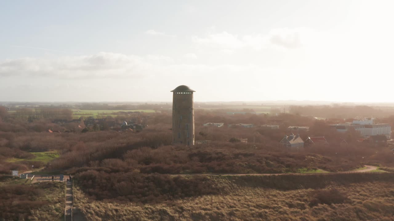 Orbit drone shot of an old water tower located in the dunes in The Netherlands
