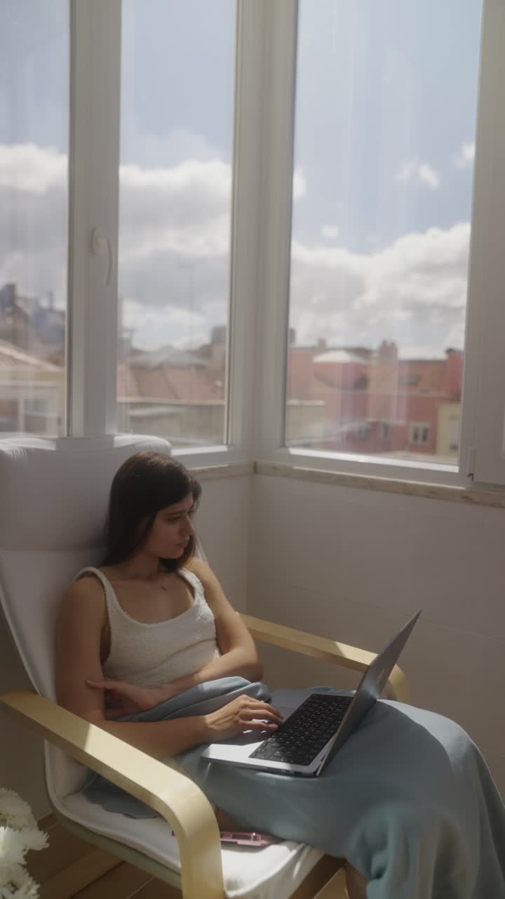 mujer trabajando en una computadora portátil en un balcón