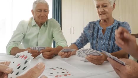 un anciano y una anciana jugando a las cartas en un hogar de ancianos