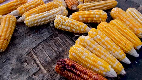 maíz dulce amarillo delicioso y saludable recién recogido en una vieja mesa rústica de madera en un puesto de mercado en el sudeste asiático