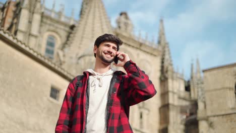 tourist examining a map and receiving a call near an ancient building