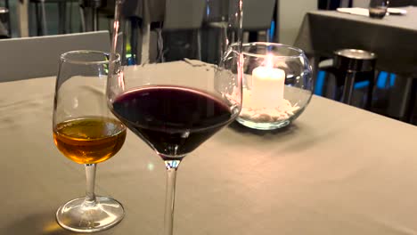 close up male hand swirling red wine in wine glass