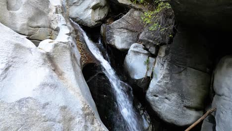 una cascada que fluye rápidamente por un acantilado rocoso - el corazón de la roca en la cresta de california