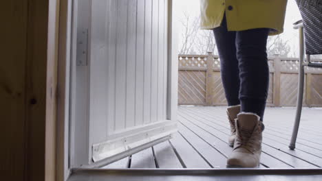 young female traveler opening the door of a wooden cabin in iceland