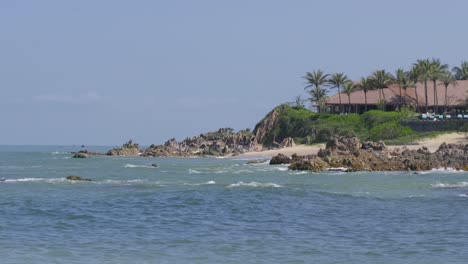 Stunning luxurious beach resort next to tropical ocean, long shot