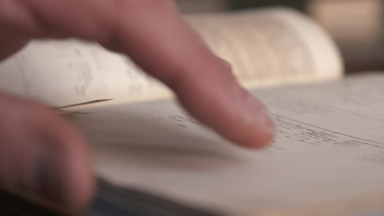 한 남자가 벨파스트의 한 도서관에서 오래된 역사책을 살펴보고 있다