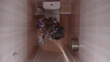 woman sitting on toilet with medical device