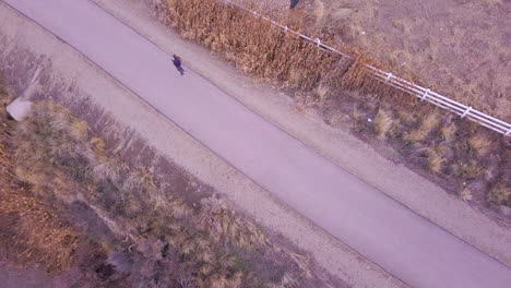 A-person-jogging-along-a-paved-path---looking-straight-down-from-above