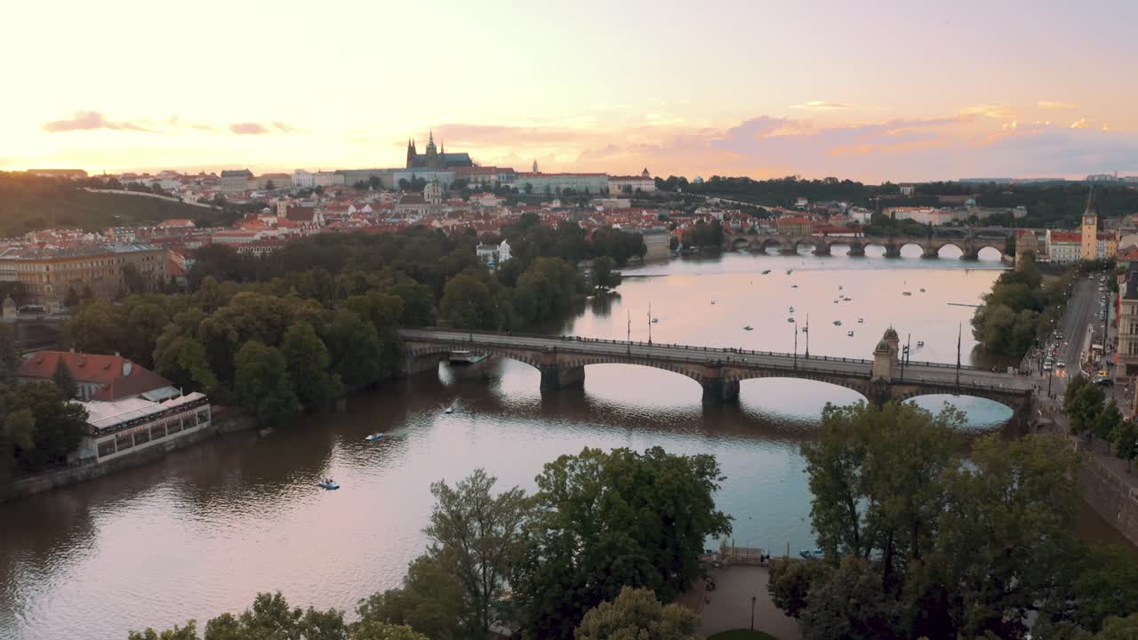 Famous Legion Bridge Spanning Across Vltava River In Prague with st vitus cathedral and castle in background. Czech Republic - ascending drone shot