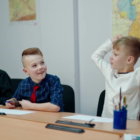 active children in classroom. little boys sitting at desk and listen to the teacher at school. happy school children study. primary education concept.