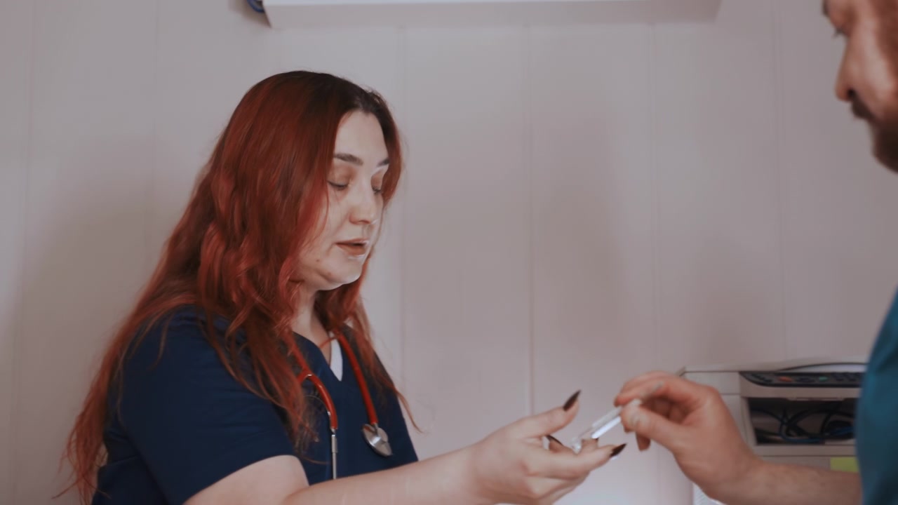 Calm nurse monitors finger blood test. Quiet indoor setting with healthcare provider attending patient. Attentive nurse seated by patient during simple blood sugar measurement procedure