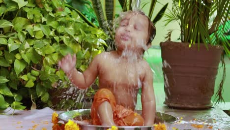 cute toddler baby boy bathing in decorated bathtub at outdoor from unique perspective