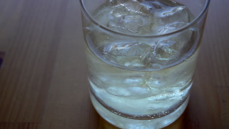 extreme close up of a bartender making a long drink with tequila and tonic water