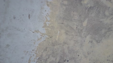 piso de hormigón sucio con basura y barandilla de metal