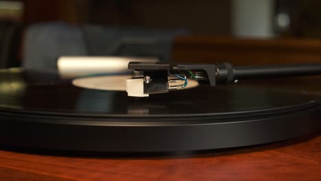 close up view of a moving up tonearm of a turntable with platter spinning, slow motion 4k